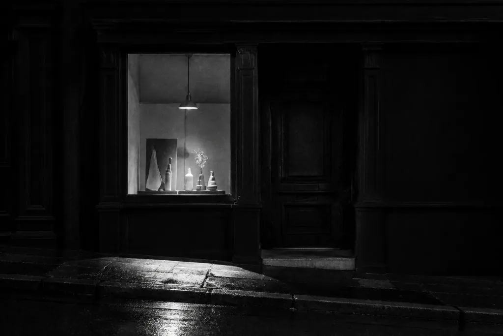A lit shop window on a quiet street at night